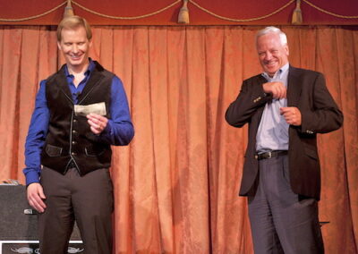 tim hall corporate magician performs with gentleman on stage at corporate party, v1