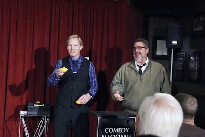 magician-tim-hall-performs-on-stage-with-laughing-volunteer