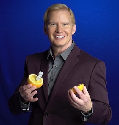 tim-hall-corporte-magician-makes-hundred-dollor-bill-appear-inside-orange