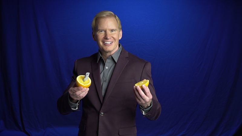 tim_hall_corporate_magician_holds_lemon_in_his_hand_